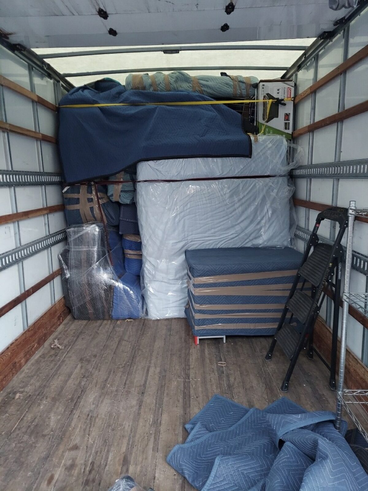 A clean, carefully loaded moving truck with a wood floor